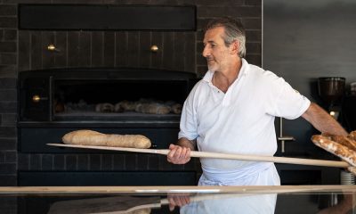 Bäcker holt Brot aus dem Holzofen