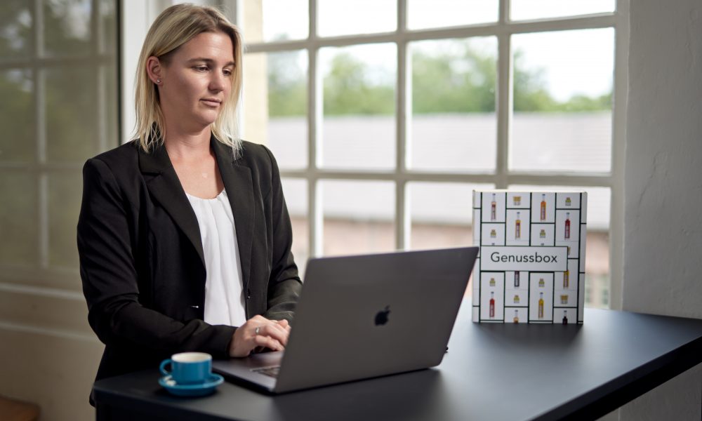 Jessica Deutsch arbeitet am Laptop an einem Schreibtisch in einem hellen Raum.