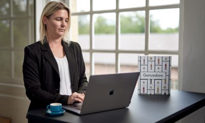 Jessica Deutsch arbeitet am Laptop an einem Schreibtisch in einem hellen Raum.