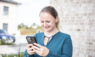 Saskia Richardsen mit Smartphone in der Hand beim Arbeiten an Social-Media-Content