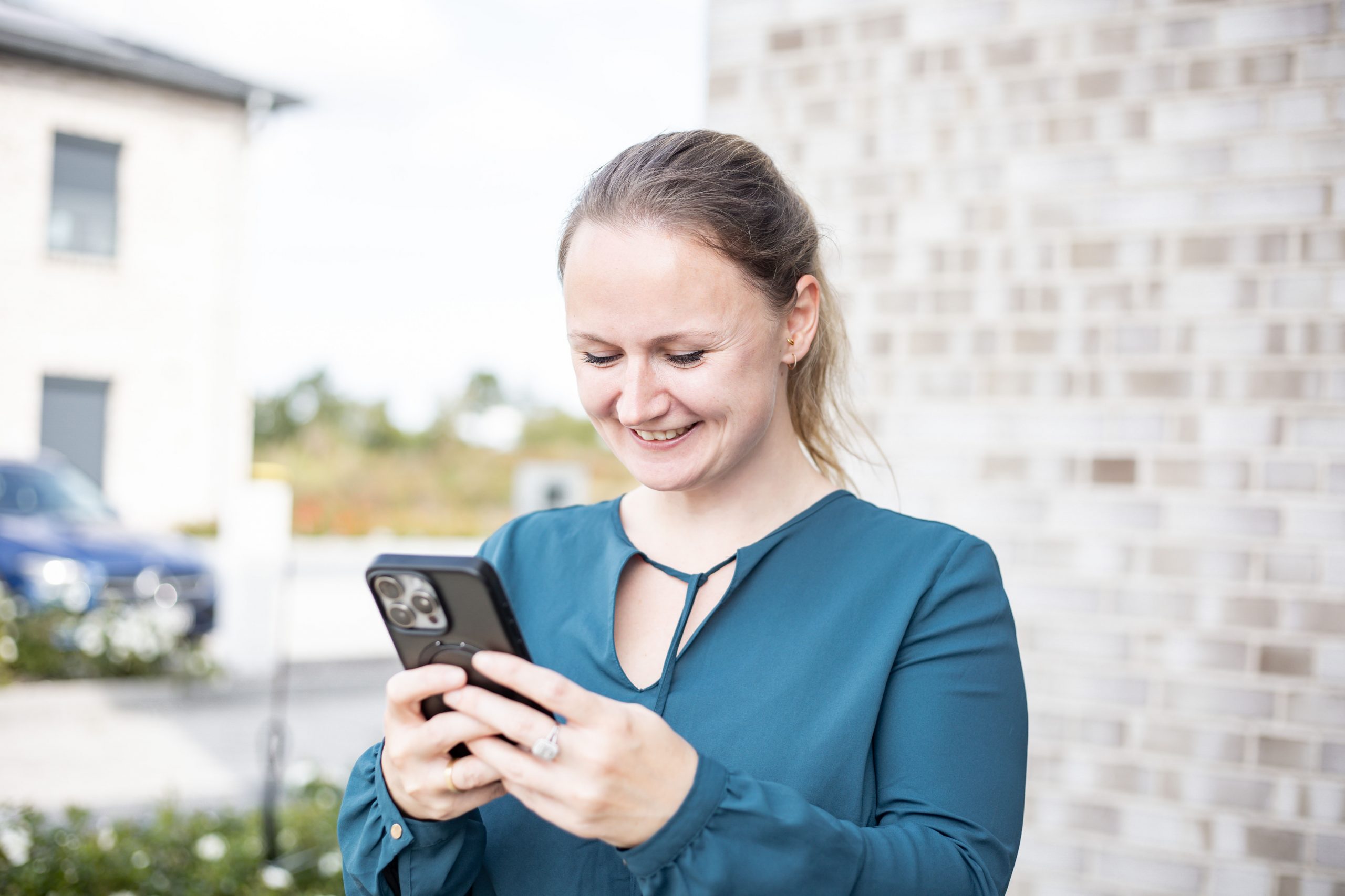 Saskia Richardsen mit Smartphone in der Hand beim Arbeiten an Social-Media-Content