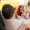 Frau von Haus Atemzeit spielt lachend mit einem beatmeten Kleinkind auf dem Boden – Begleitung im Alltag der Übergangseinrichtung Übergangseinrichtung für beatmete Kinder